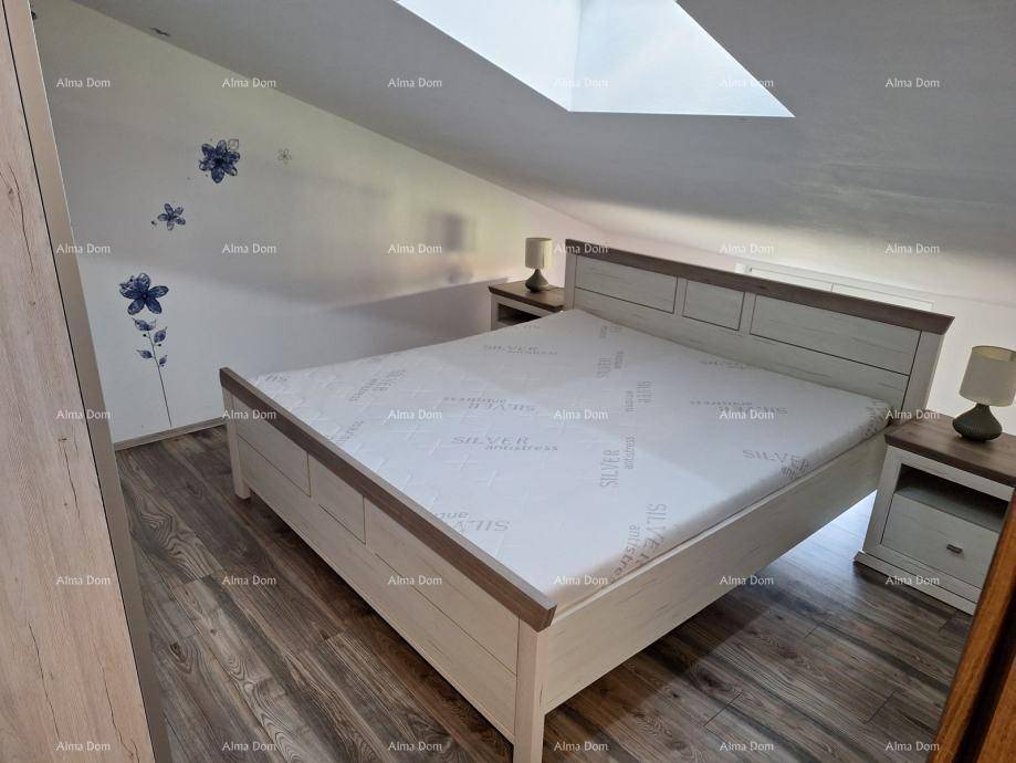 Gemütliches Schlafzimmer mit Doppelbett, Nachttischen und einem Dachfenster für natürliches Licht.