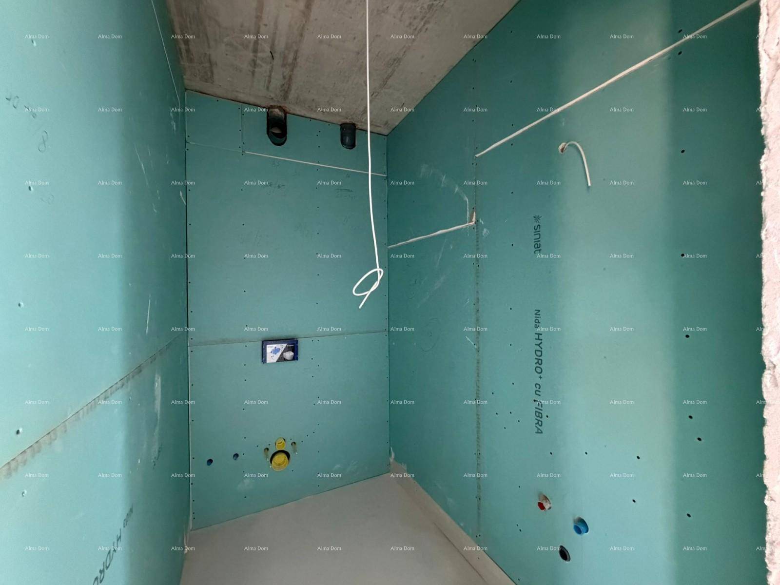 Badezimmer im Rohbau mit grünen Trockenbauwänden und vorbereiteten Sanitärinstallationen.
