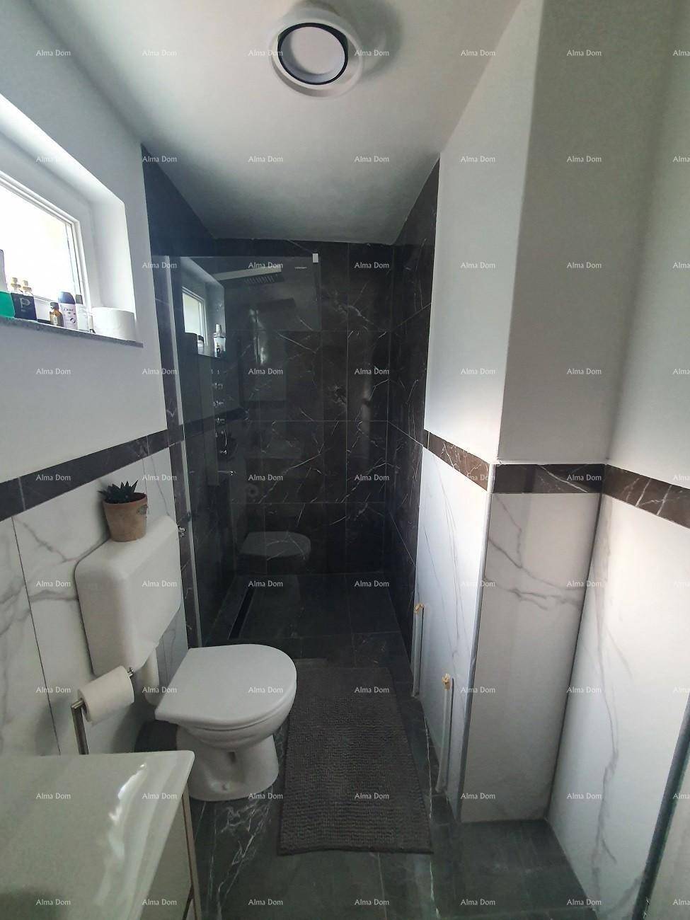 Modernes Badezimmer mit dunklen Marmorfliesen, Duschkabine und wandmontierter Toilette.