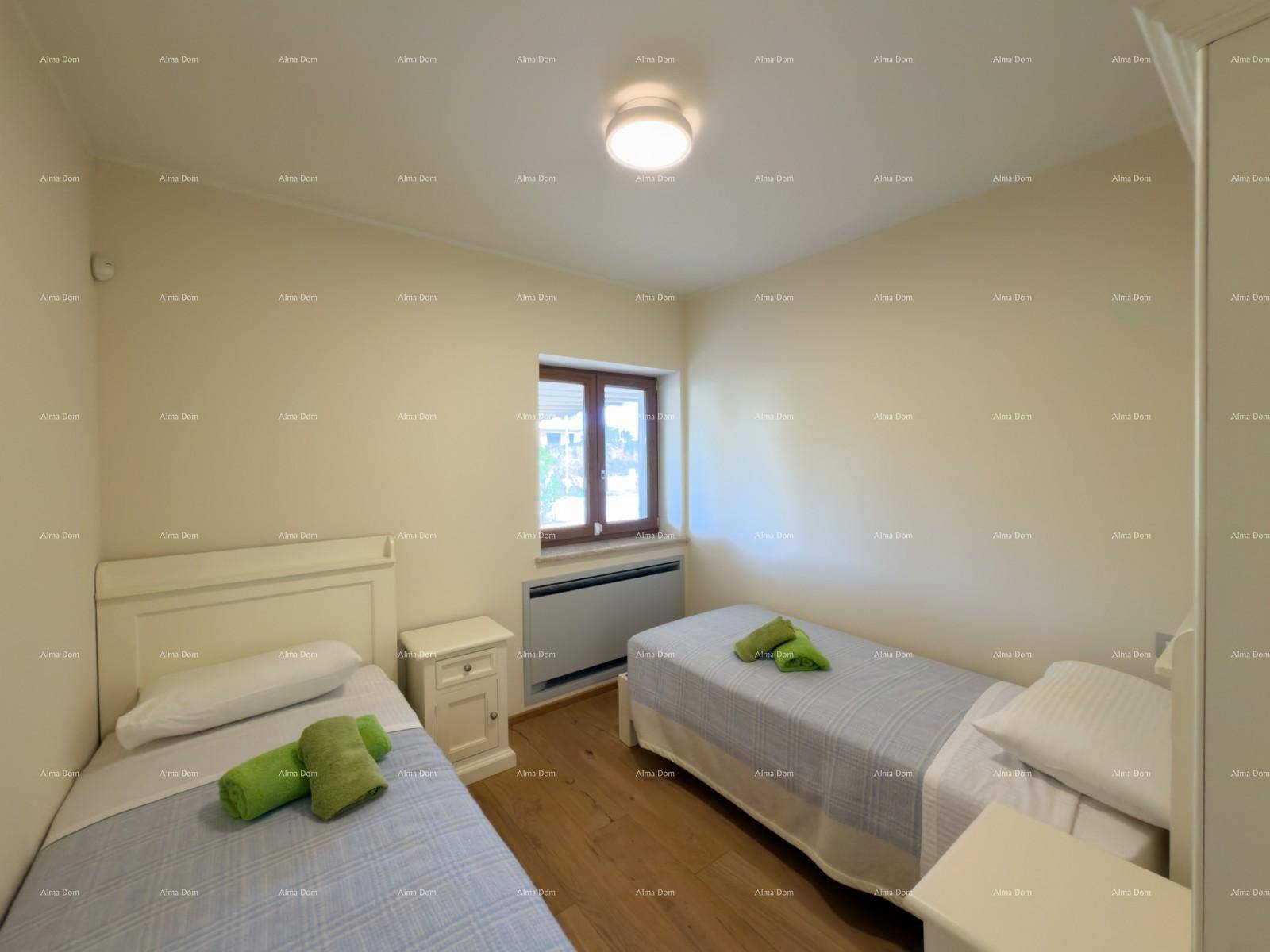 Helles Schlafzimmer mit zwei Einzelbetten und einem Fenster, ausgestattet mit Holzfußboden.