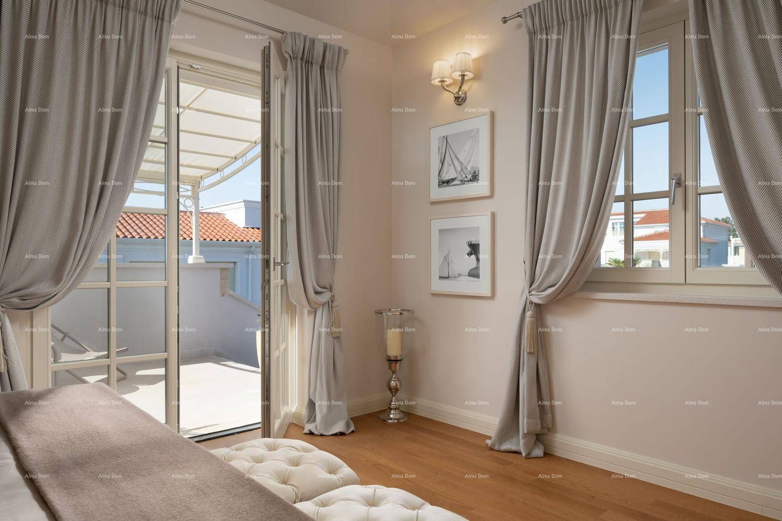 Helles Schlafzimmer mit Holzboden, Zugang zur Terrasse und großen Fenstern.