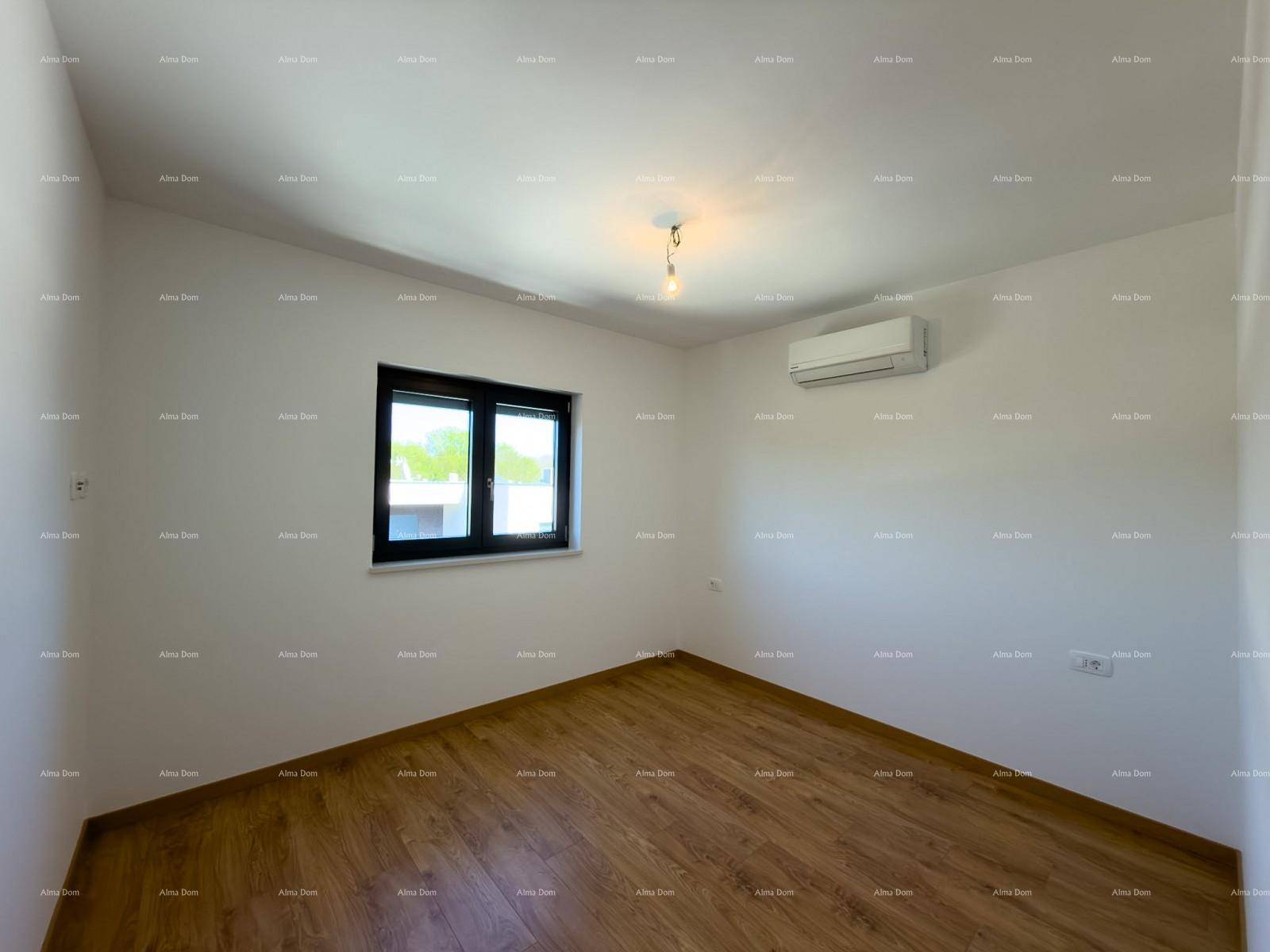 Helles Schlafzimmer mit Holzfußboden, Klimaanlage und einem Fenster mit Blick ins Grüne.