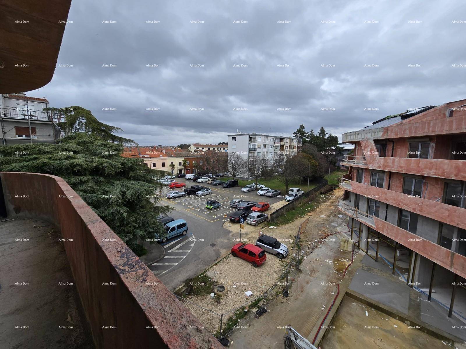 Blick von einem Balkon auf einen Parkplatz und die umliegende städtische Bebauung.