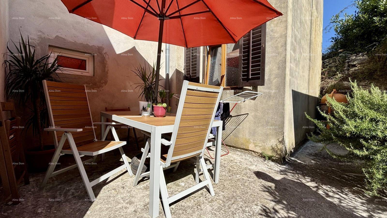 Gemütliche Terrasse mit Esstisch, Stühlen und einem Sonnenschirm, ideal für Mahlzeiten im Freien.