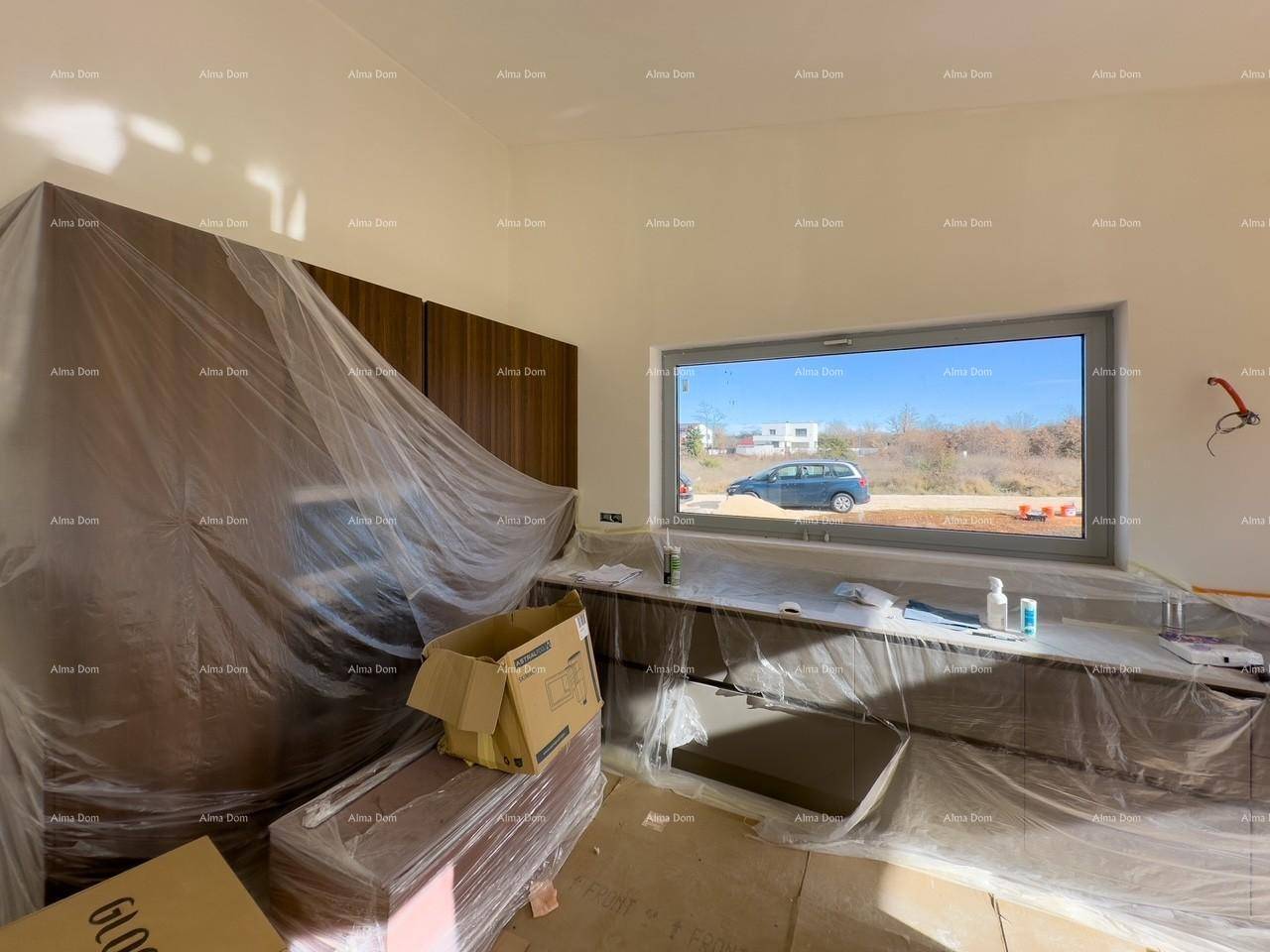 Unfertige Küche mit bereits installierten, folierten Schränken und einem Fenster mit Ausblick.