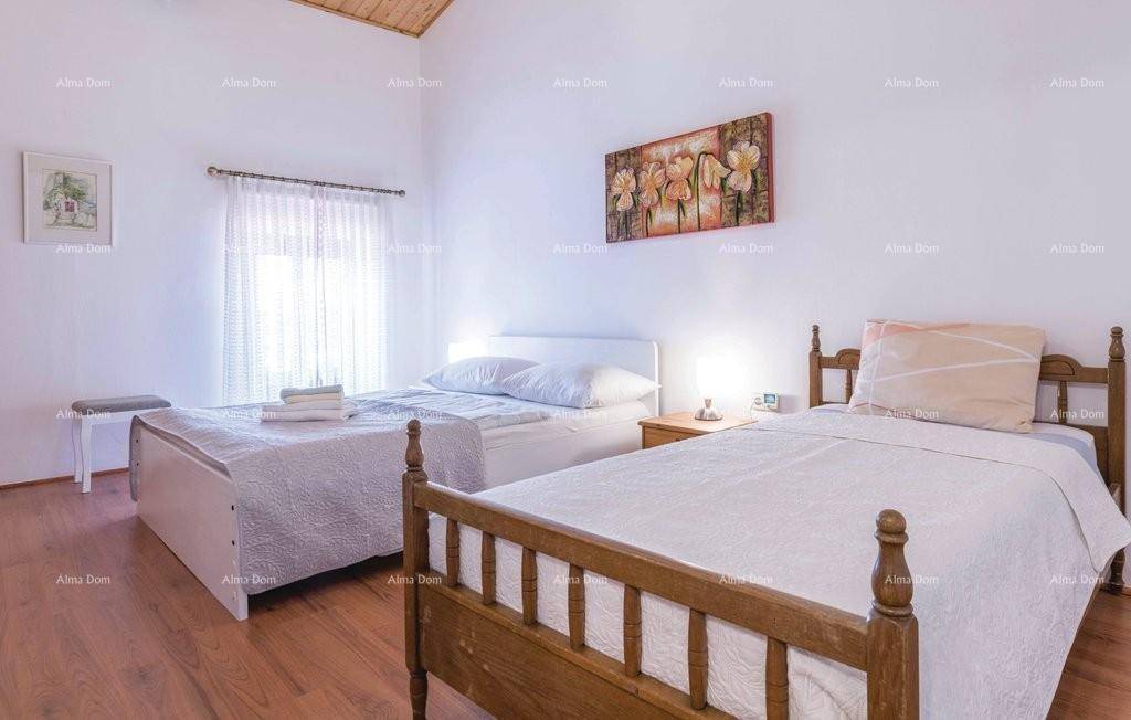 Helles Schlafzimmer mit zwei Betten, Holzboden und traditioneller Einrichtung.