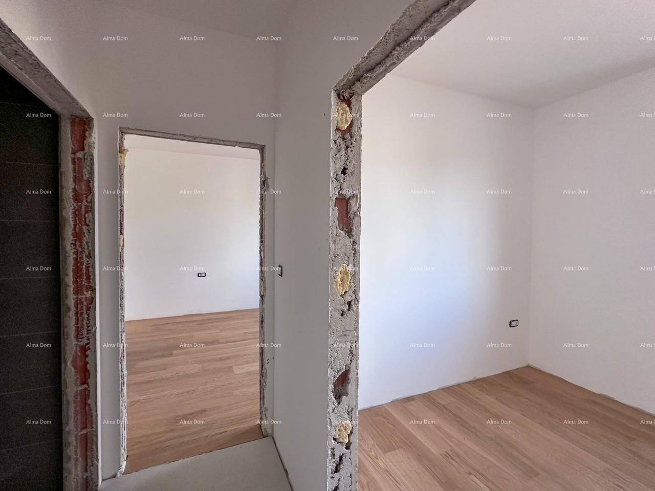 Unfertiger Flur mit unverputzten Türrahmen und Blick in ein Zimmer mit Holzboden.