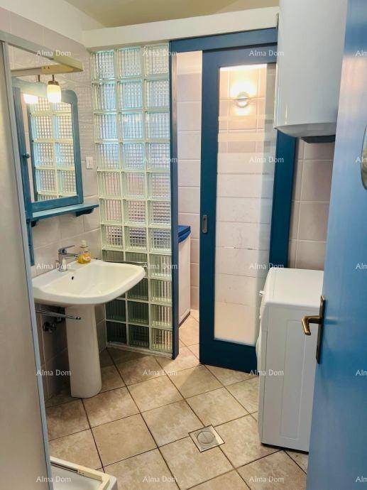 Badezimmer mit Standwaschbecken, Waschmaschine und einer Duschabtrennung aus Glasbausteinen.