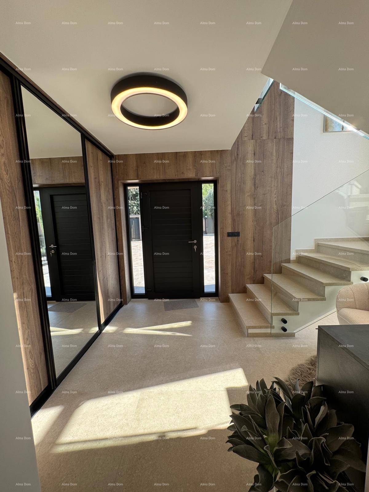 Heller Eingangsbereich mit Holzwänden, moderner Deckenleuchte und Blick auf die Treppe.