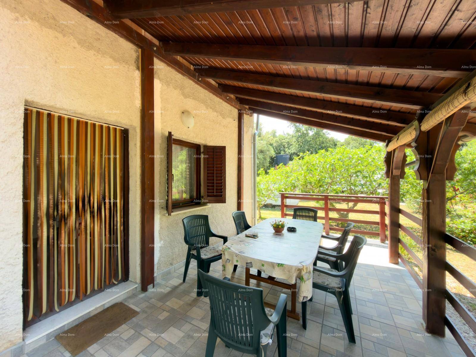 Gemütliche überdachte Terrasse mit Holzbalken und Gartenmöbeln, ideal für Mahlzeiten im Freien.