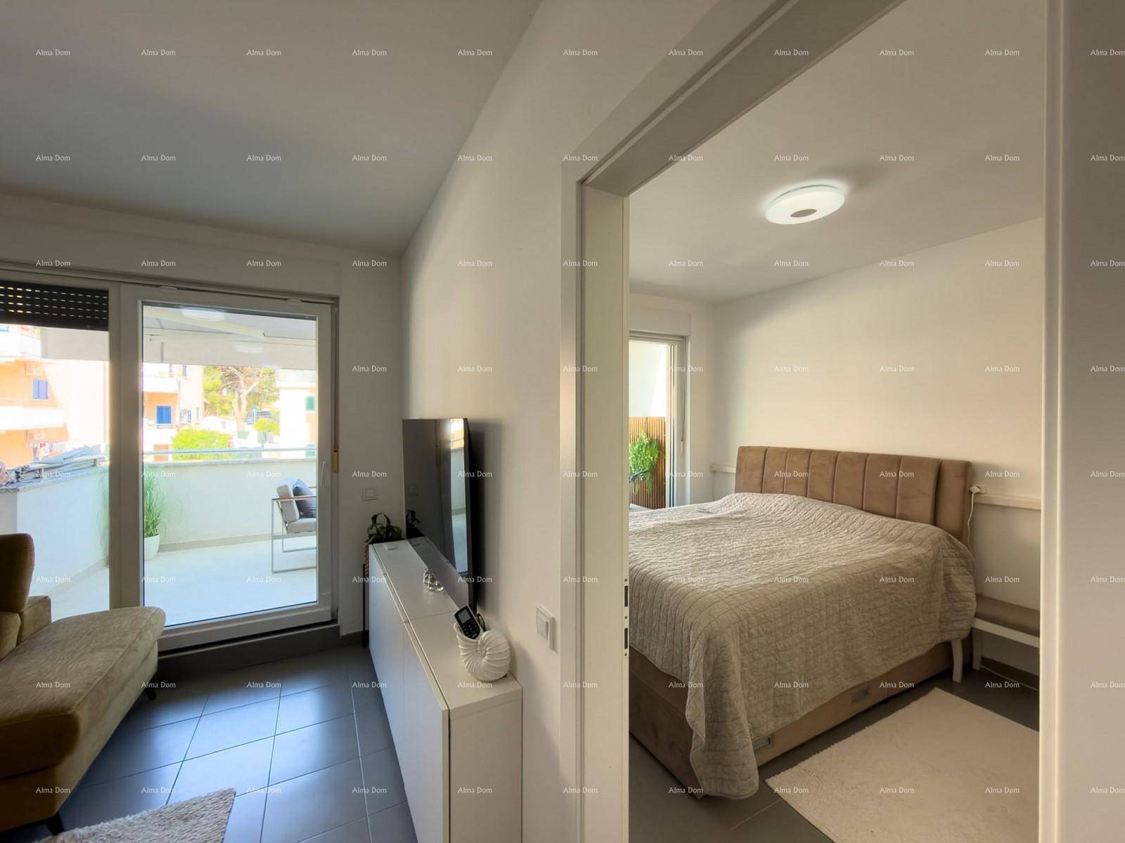 Helles Wohnzimmer mit Zugang zum Balkon und Blick in ein Schlafzimmer.