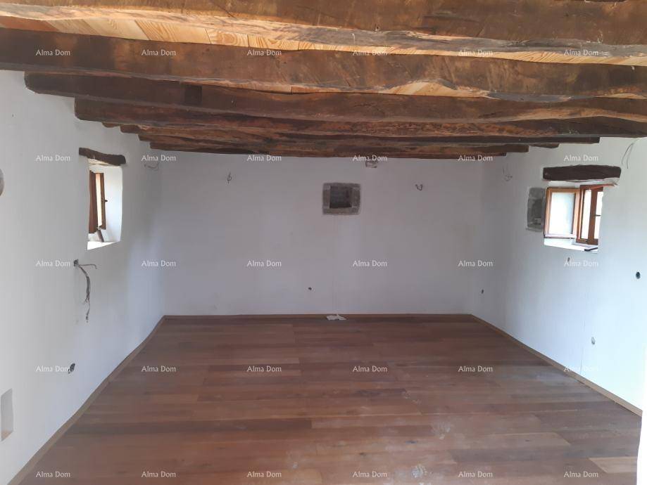 Renovierter Raum mit neuen Holzdielen und freiliegenden Deckenbalken, hell und geräumig.
