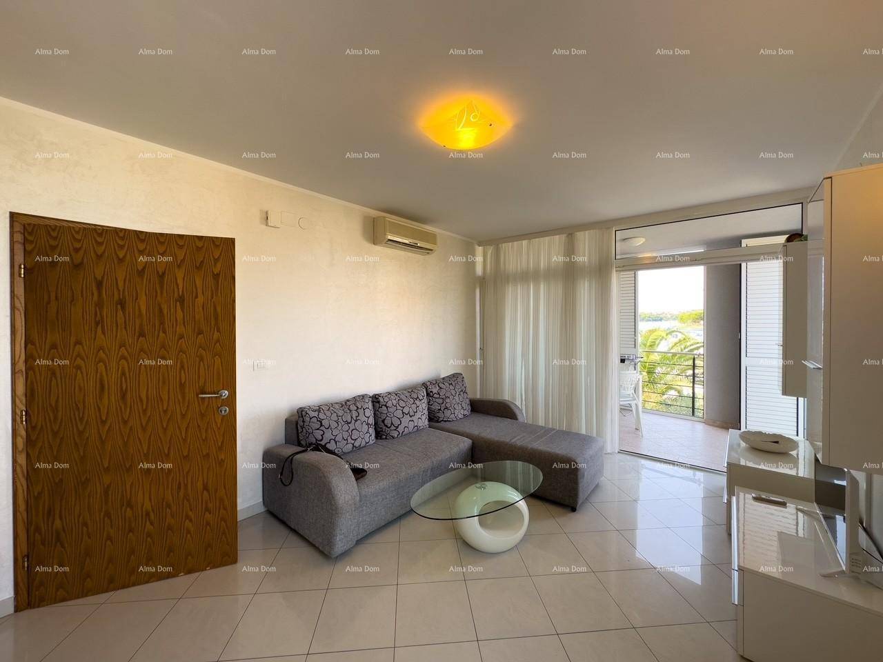 Gemütliches Wohnzimmer mit Sofa, Couchtisch und Zugang zu einem Balkon mit Meerblick.