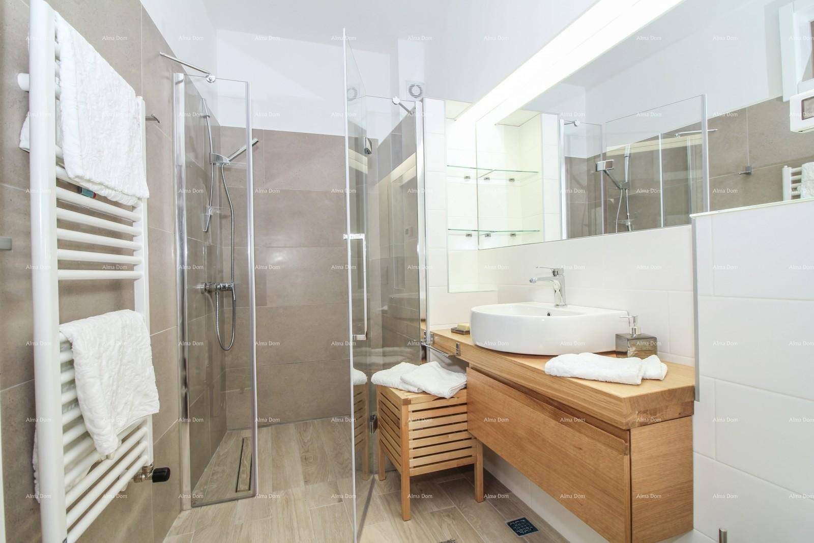 Elegantes Badezimmer mit Glasdusche, Holzwaschtisch und großem Spiegel.