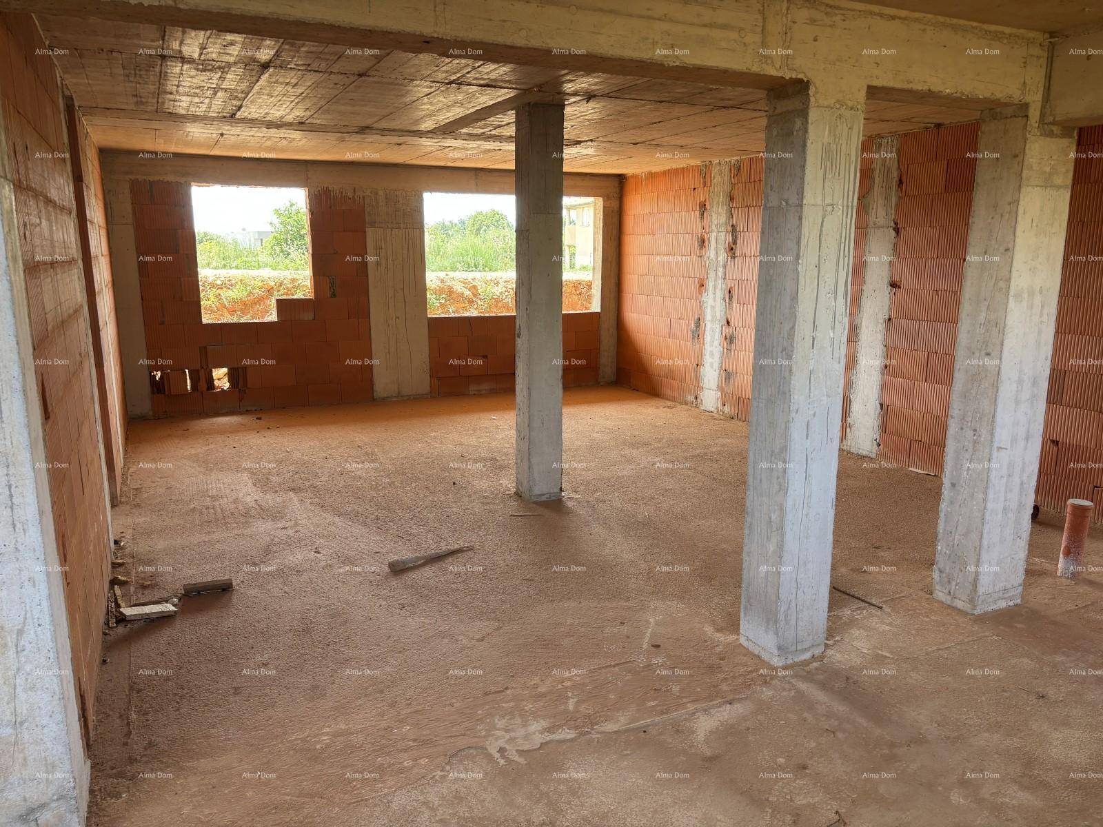 Innenraum im Rohbau mit Betonstützen und Blick nach draußen durch die Fensteröffnungen.