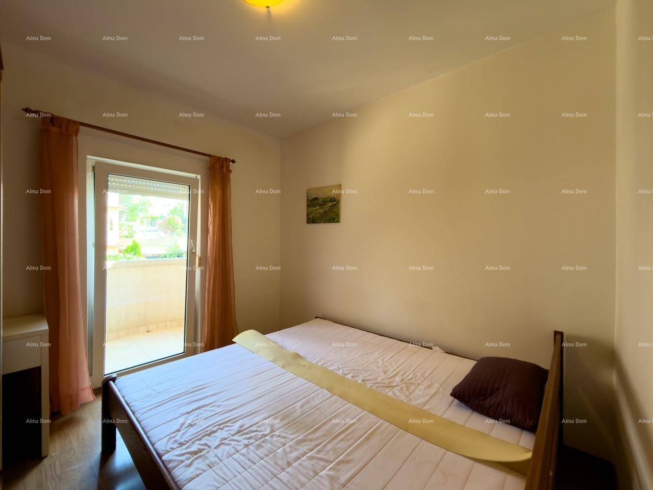 Schlafzimmer mit Bett, Holzboden und direktem Zugang zum Balkon.