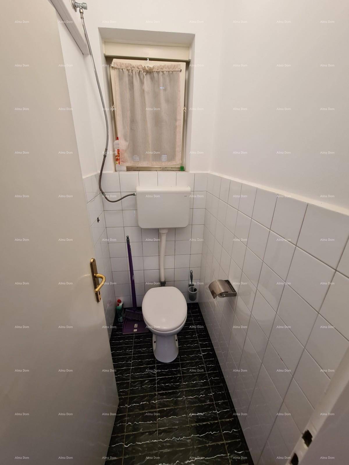 Einfaches Gäste-WC mit Fenster, weißen Fliesen und dunklem Boden.