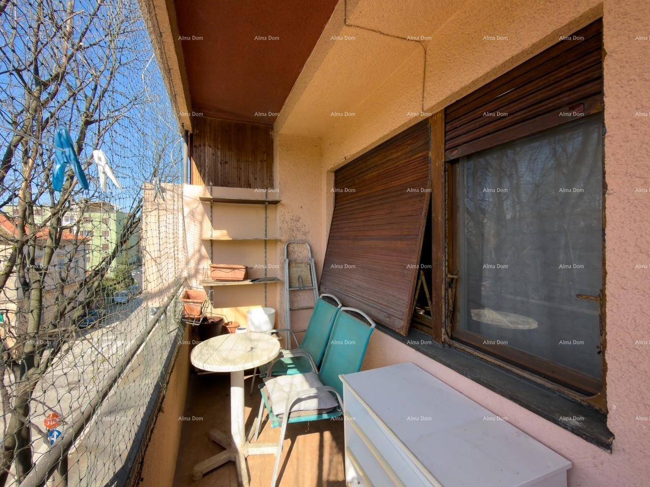 Balkon mit Sitzgelegenheiten, Regalen und Fenster mit Rollladen.