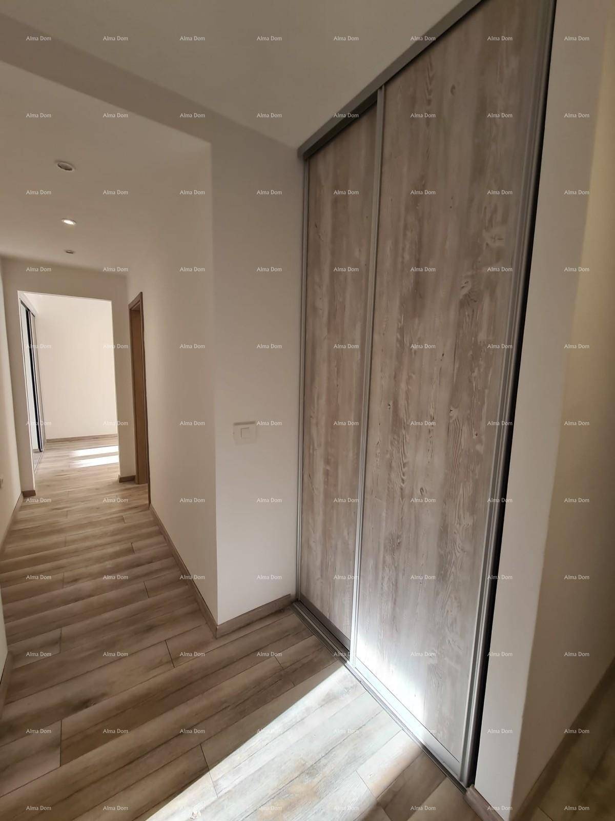 Langer Flur mit Holzoptik-Fliesenboden und einem großen Einbauschrank mit Schiebetüren.