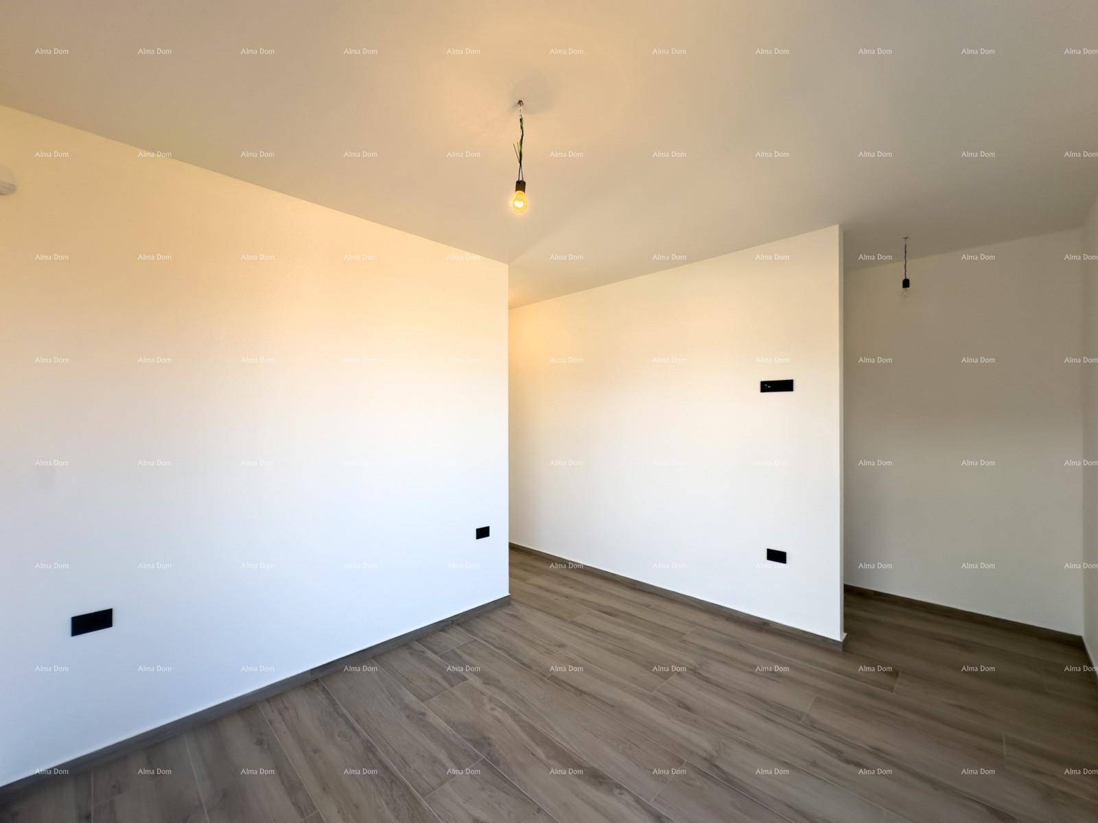 Heller Raum mit Holzoptik-Boden und großem Fenster, das viel Licht hereinlässt.
