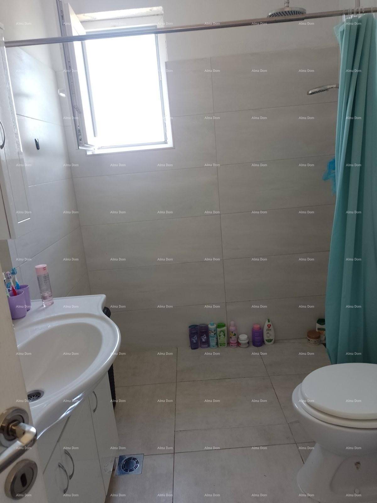 Funktionales Badezimmer mit Fliesenboden, Dusche, WC und einem Fenster für Tageslicht.