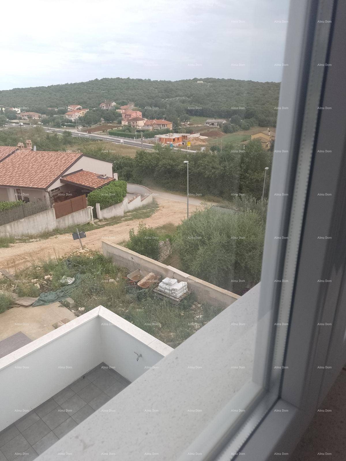 Blick aus dem Fenster auf die umliegende Landschaft mit Häusern und grünen Hügeln.