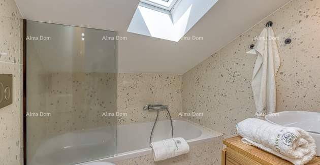 Modernes Badezimmer mit Dachschräge, Badewanne und Oberlicht für natürliches Licht.