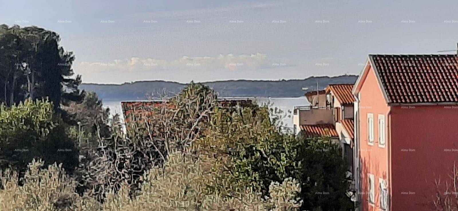 Panoramablick auf das Meer und die umliegende Landschaft mit grünen Hügeln und Gebäuden.