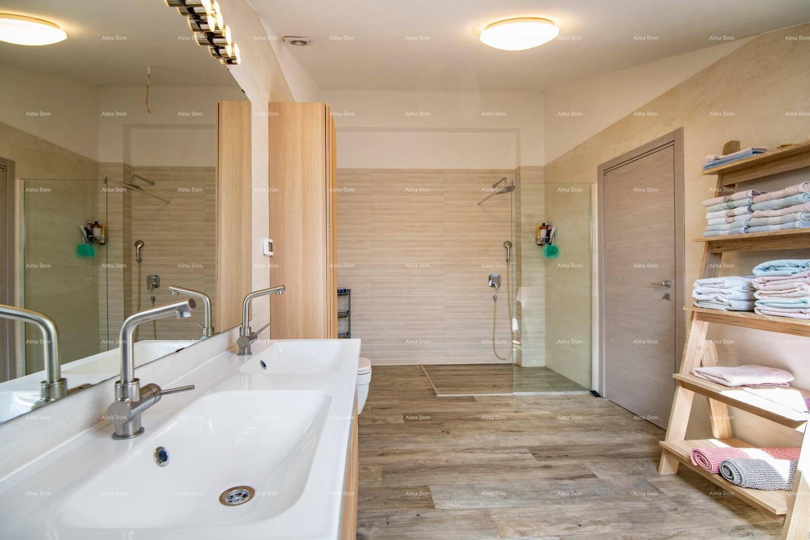 Geräumiges Badezimmer mit Doppelwaschbecken, großer begehbarer Dusche und Holzoptik-Fliesen.