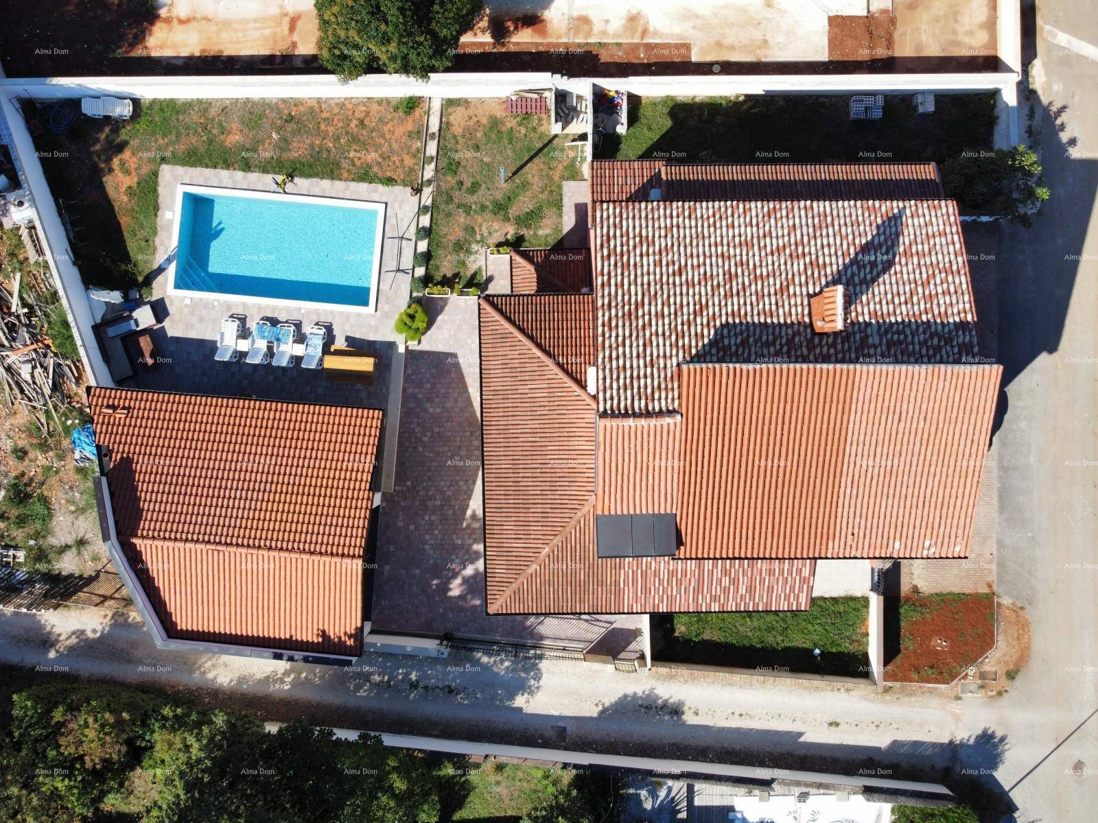 Senkrechte Luftaufnahme des Hauses mit Ziegeldächern und dem rechteckigen Swimmingpool.