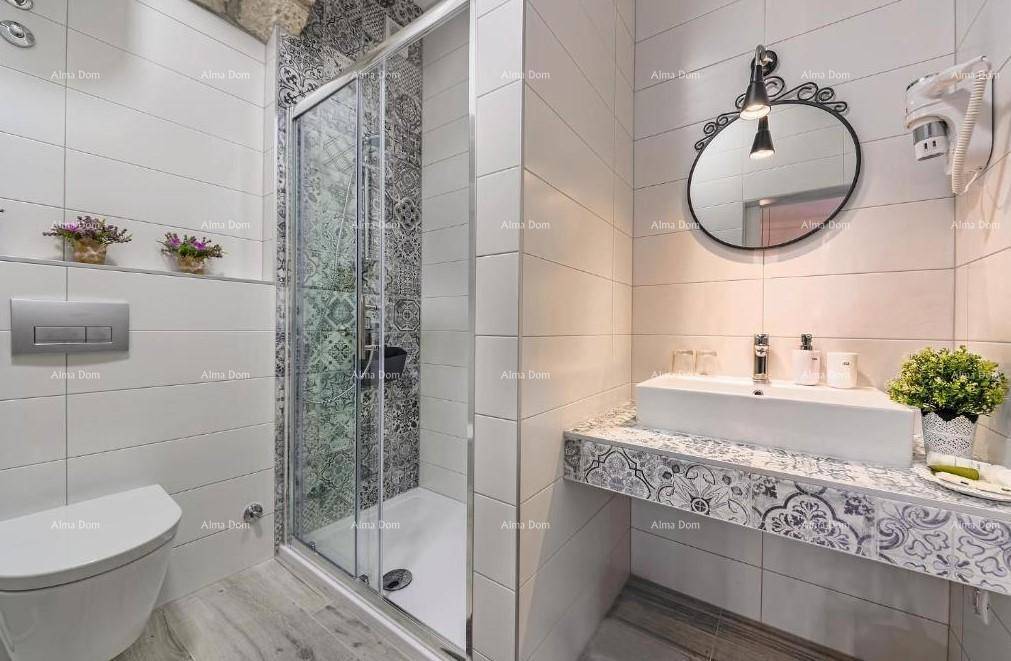 Modernes Badezimmer mit Duschkabine, Wand-WC und dekorativen Fliesen am Waschtisch.