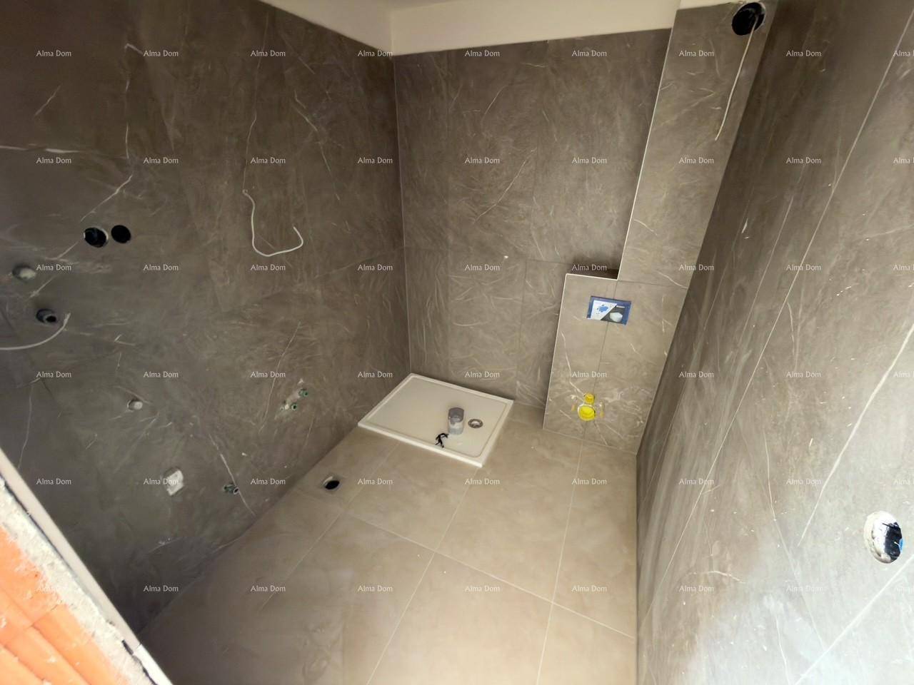 Modernes Badezimmer im Rohbau mit großformatigen Fliesen und vorbereiteter Duschwanne.