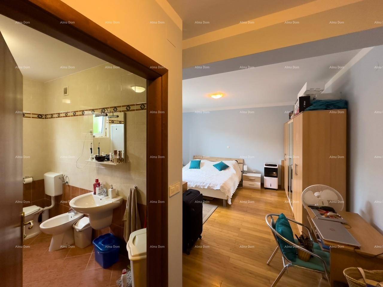 Schlafzimmer mit Holzboden und direktem Zugang zu einem gefliesten Badezimmer, komfortabel und praktisch.