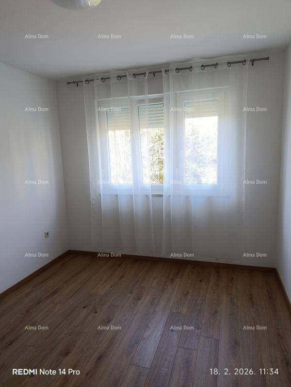 Helles Schlafzimmer mit Laminatboden und einem großen Fenster für viel Tageslicht.