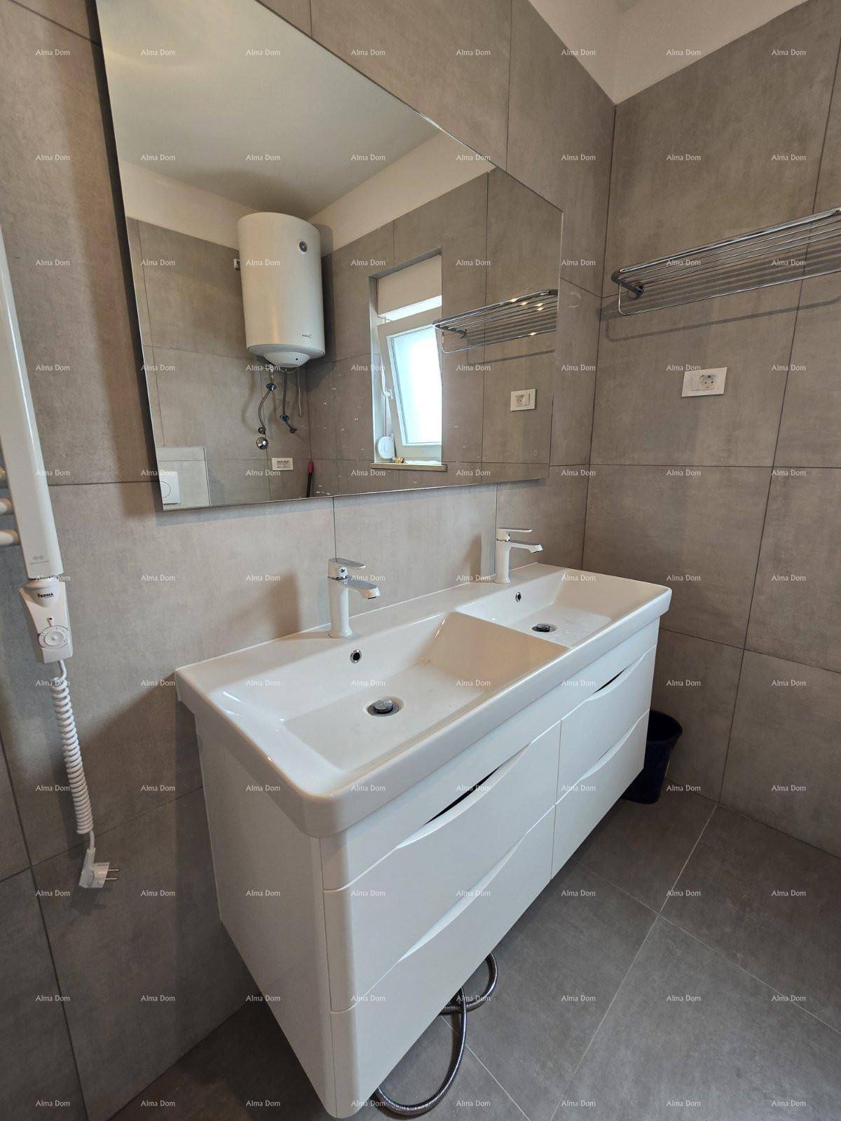 Doppelwaschbecken mit großem Spiegel in einem modern gefliesten Badezimmer.