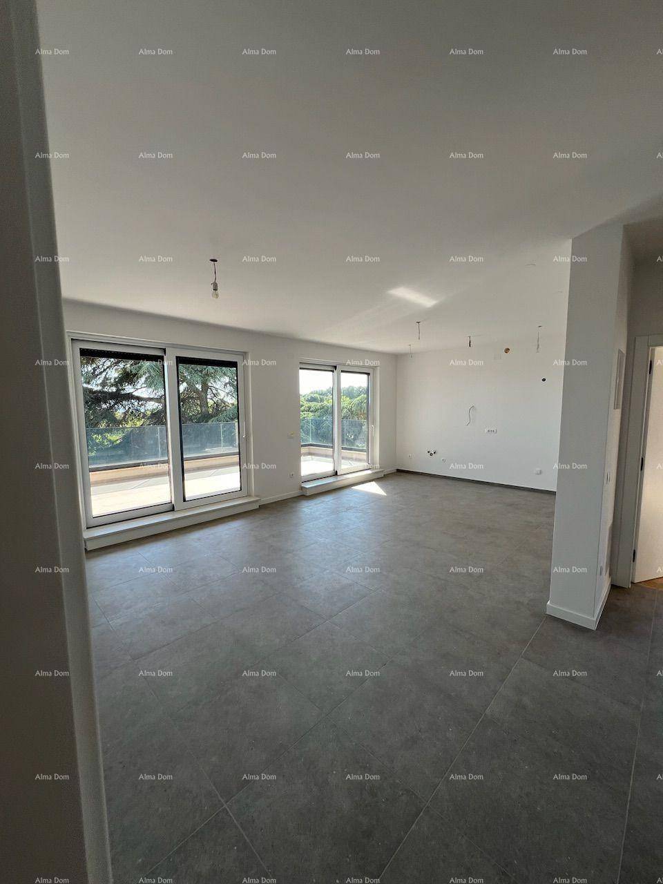Geräumiger, unmöblierter Wohnbereich mit großen Schiebetüren und dunklem Fliesenboden.
