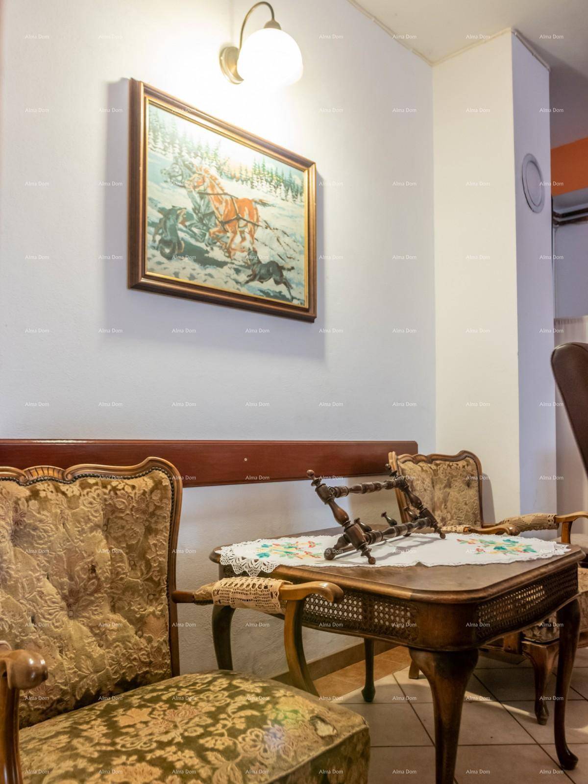 Ecke mit Vintage-Möbeln, einem Sessel, kleinem Tisch und einem Gemälde an der Wand.