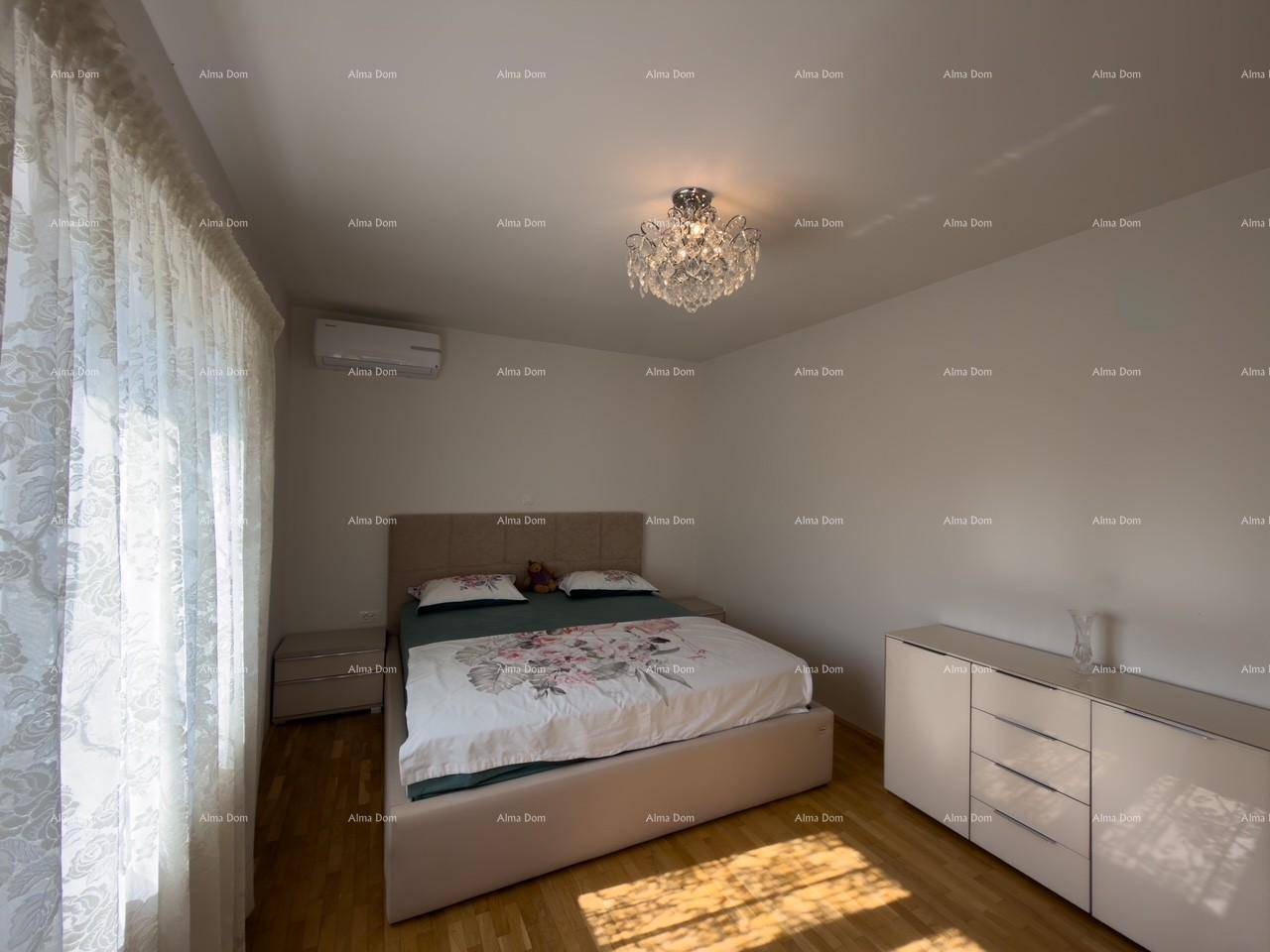Gemütliches Schlafzimmer mit Doppelbett, Holzboden und Kronleuchter, hell durch Tageslicht.