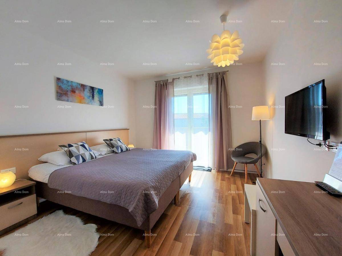 Gemütliches Schlafzimmer mit Doppelbett, Holzboden und einem Fenster, das viel Tageslicht hereinlässt.