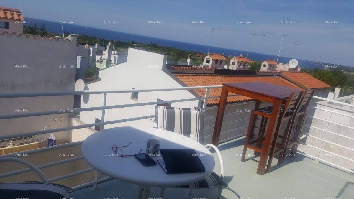 Sonnige Dachterrasse mit Meerblick, ausgestattet mit einem Esstisch und Stühlen.