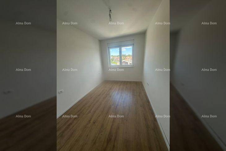 Helles Schlafzimmer mit Laminatboden und einem Fenster, das einen Blick nach draußen bietet.