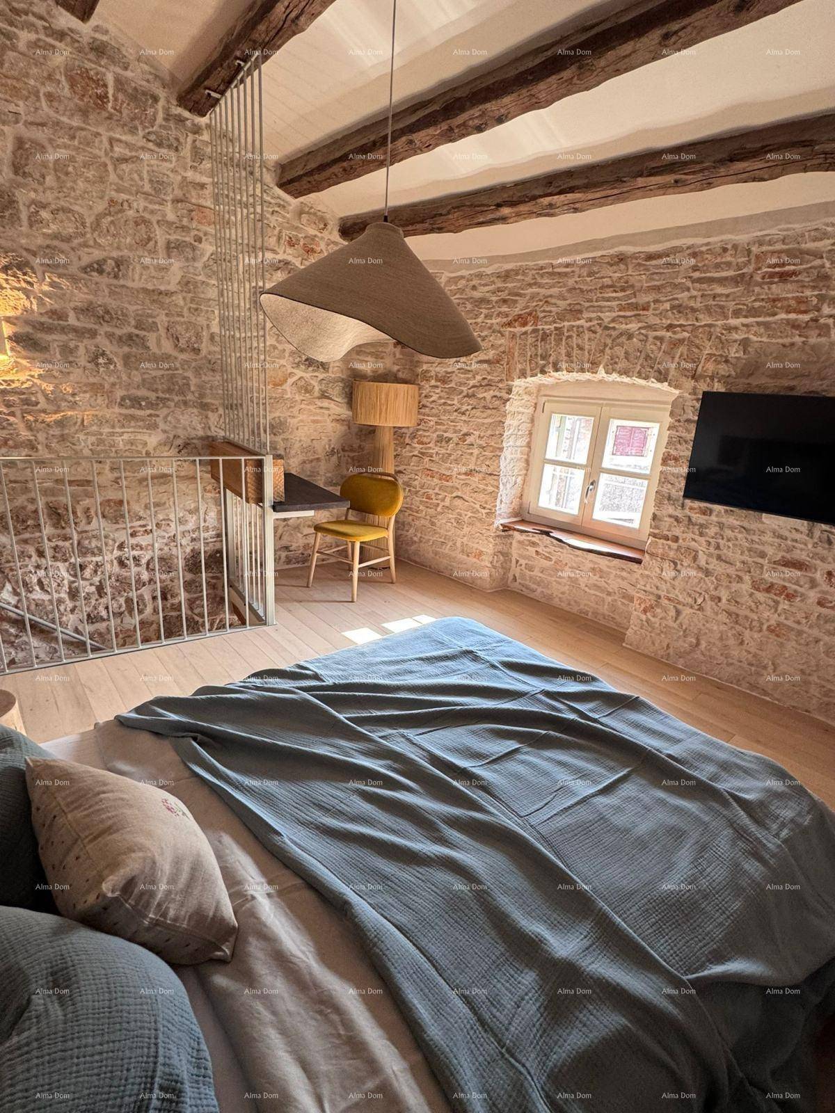 Schlafzimmer mit Holzboden, Steinwänden und einem großen Bett.