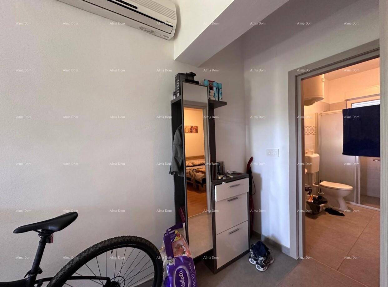 Flur mit Spiegel, Kommode und Blick in ein angrenzendes Badezimmer.