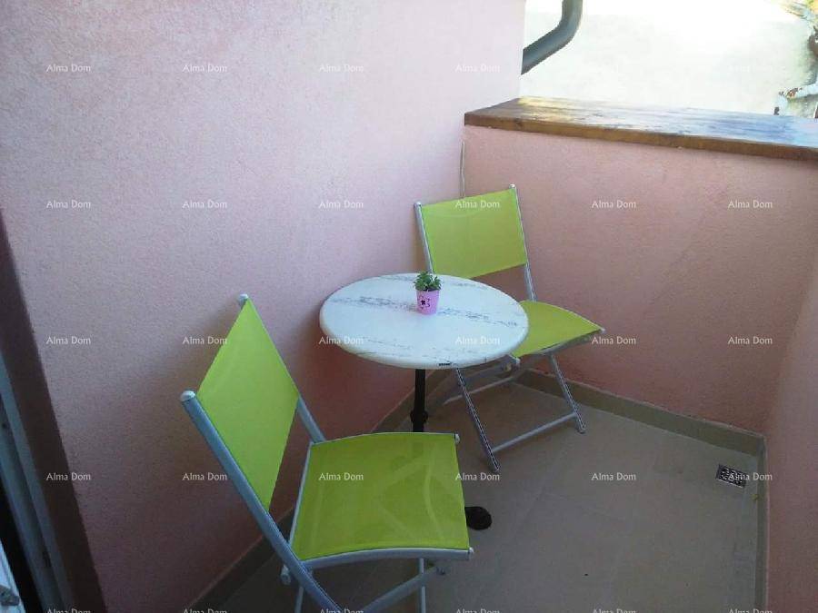 Kleiner Balkon mit Tisch und zwei Stühlen, perfekt für eine ruhige Auszeit im Freien.