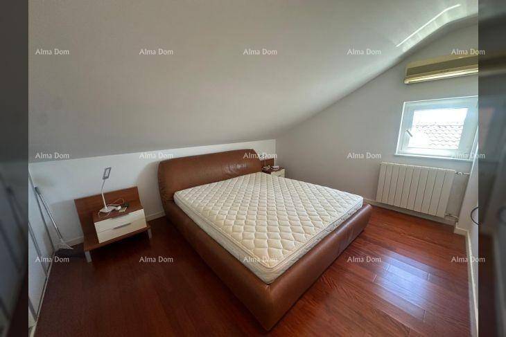 Helles Schlafzimmer im Dachgeschoss mit Doppelbett, Holzboden und Fenster.