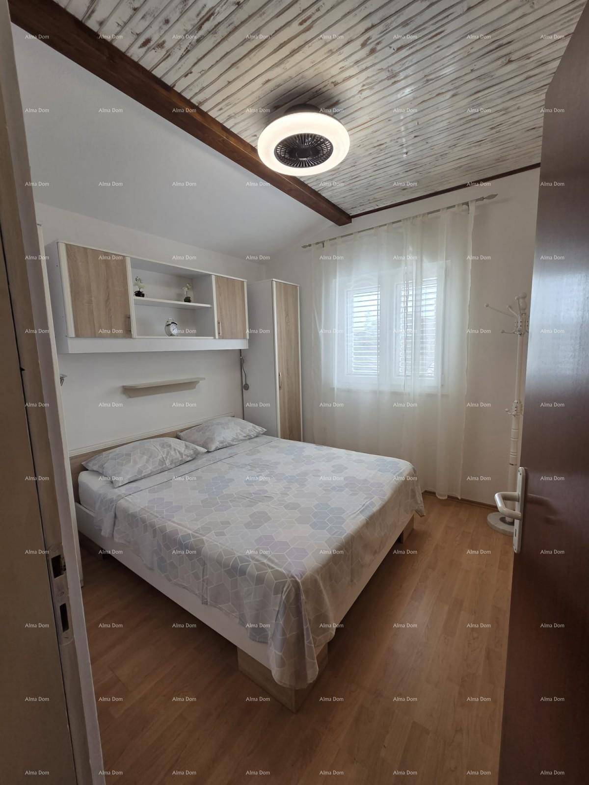 Helles Schlafzimmer mit Doppelbett, Einbauschränken und Holzbalkendecke.