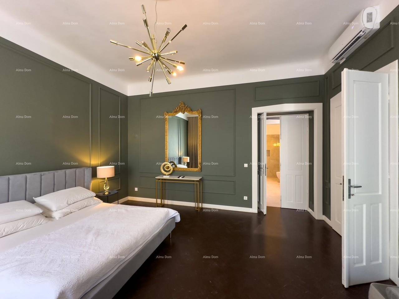 Schlafzimmer mit eleganten Wandpaneelen, großem Spiegel und direktem Zugang zu einem weiteren Raum.