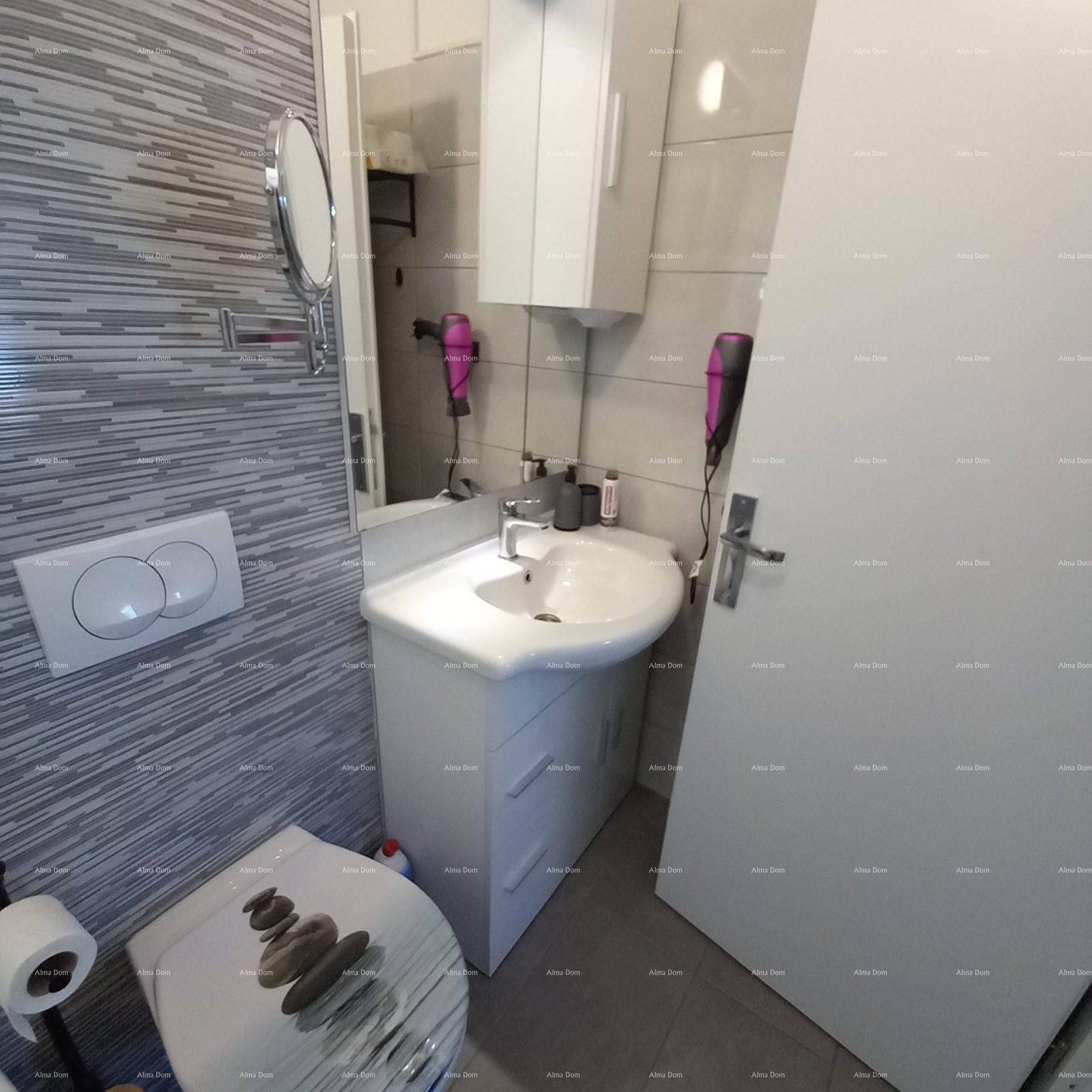 Kleines WC mit modern gefliesten Wänden, Waschbecken und Spiegelschrank.