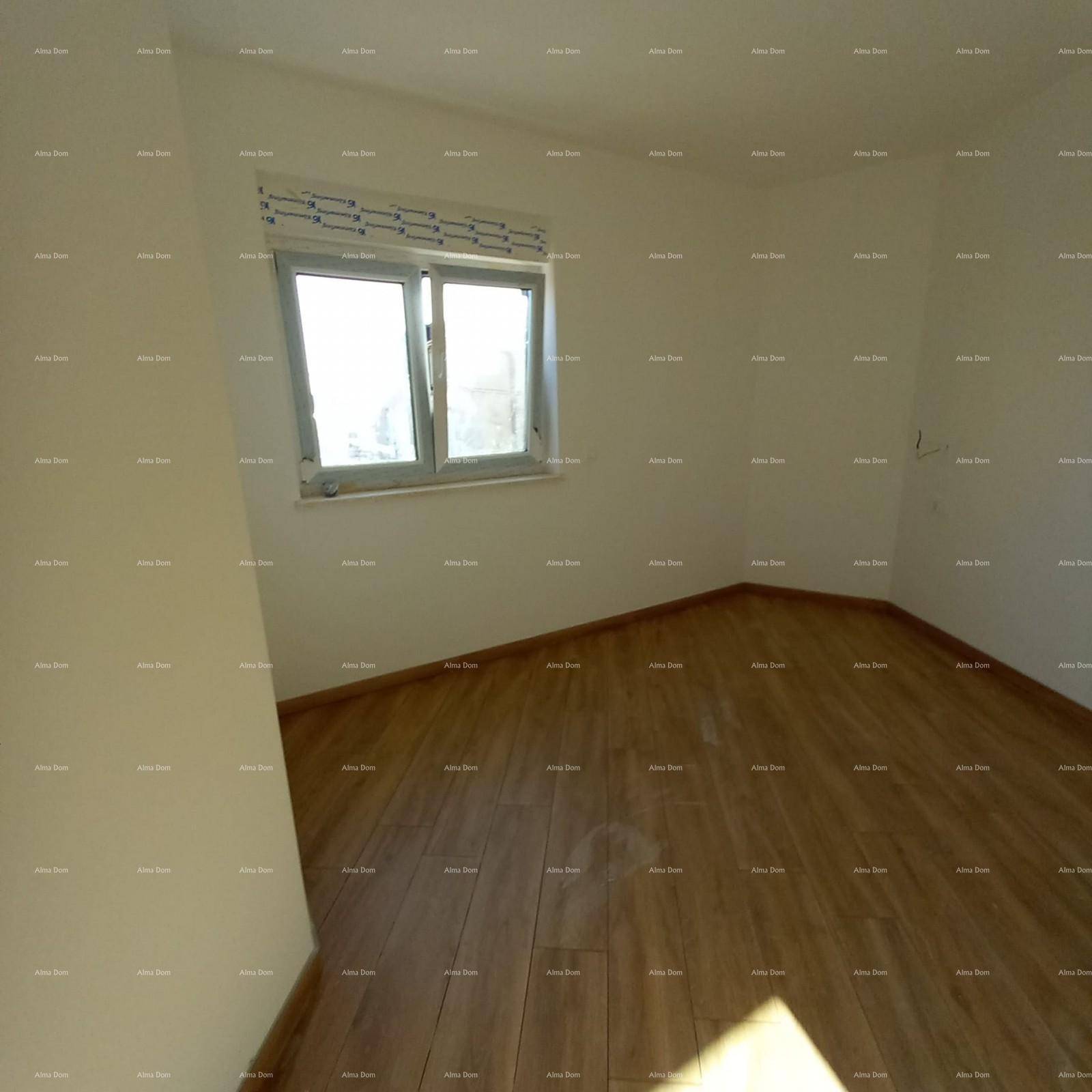 Helles Zimmer mit schräger Decke, Fenster und neuem Fliesenboden in Holzoptik.