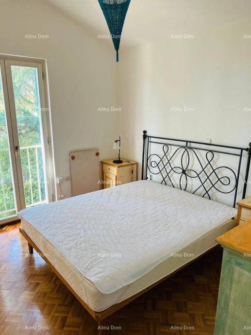 Schlafzimmer mit Doppelbett, schmiedeeisernem Kopfteil und Zugang zu einem französischen Balkon.